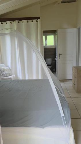 a white bed with a canopy in a room at Villa Kowosol in Le Marin