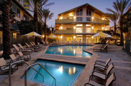a swimming pool with chairs and a building at Nautical 2 Bedroom with Beautiful Ocean Views in Los Angeles