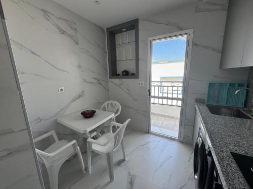 a kitchen with a table and chairs and a window at Marina Smir Apartment in Marina Smir