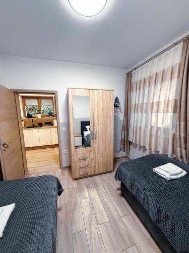 a bedroom with two beds and a large mirror at L Apartment II in Maribor