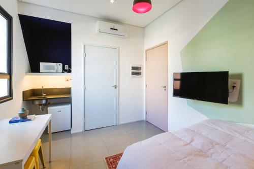 a bedroom with a bed and a tv on the wall at Hotel Centro433 in Sao Paulo