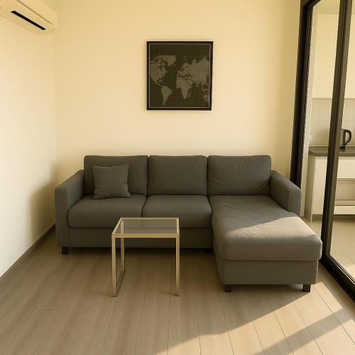 a living room with a couch and a table at 1 Bedroom Bangkok Skyline View Apartment At ON-NUT in Bangkok
