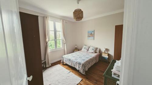 sypialnia z łóżkiem i oknem w obiekcie La Maison Verdemar w mieście Hendaye