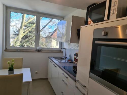 a kitchen with a window and a sink and a microwave at Komfortable Wohnung im Herzen des Ruhrpotts in Bochum