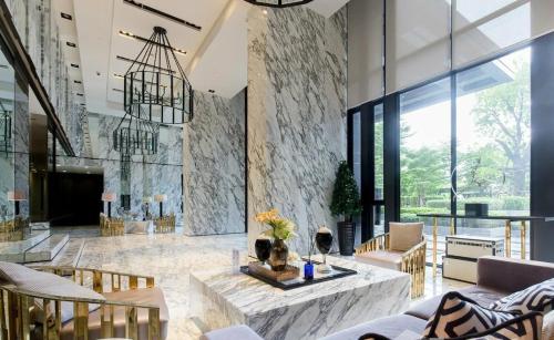 a lobby with a large stone wall and a table at 1 Bedroom Bangkok Skyline View Apartment At ON-NUT in Bangkok