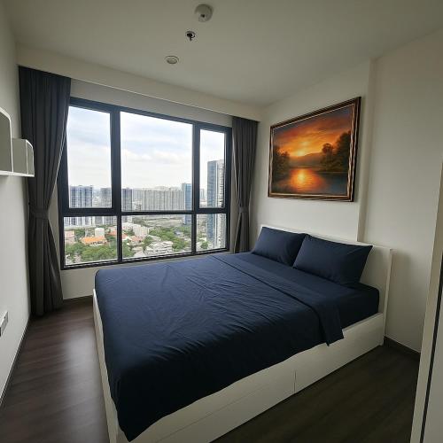 a bedroom with a bed and a large window at 1 Bedroom Bangkok Skyline View Apartment At ON-NUT in Bangkok