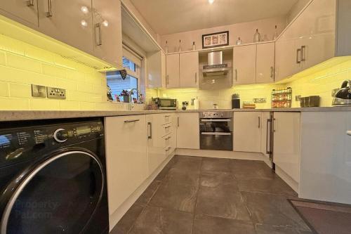 cocina con lavadora y lavavajillas en Morrison Park - West Strand Portrush, en Portrush