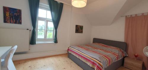 a small bedroom with a bed and a window at Victorias Apartment in Graz
