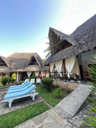 a row of surfboards on a bench in front of a house at Rafiki Villa in Mombasa