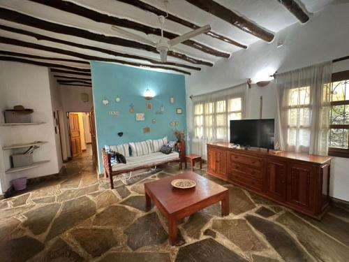 a living room with a couch and a tv at Rafiki Villa in Mombasa