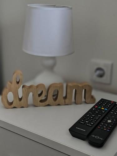 a remote control sitting next to a word on a counter at PANORAMA Apartment Sombor in Sombor