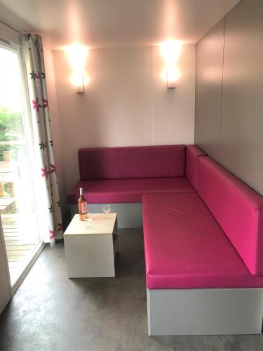 a room with a red couch and a table at Mobilhome camping Rivage des Landes in Aureilhan