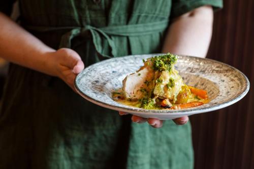 a person holding a plate of food on a plate at Hotell Sillen in Lysekil