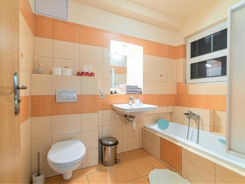 a bathroom with a toilet and a sink and a tub at Apartmány Vila Hedvika in Rožnov pod Radhoštěm
