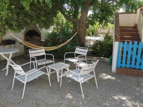 a group of chairs and a table and a hammock at Villa Lucky in Punta Prosciutto