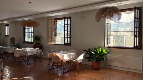 a restaurant with white tables and chairs and windows at Hotel los Tilos in Beteta