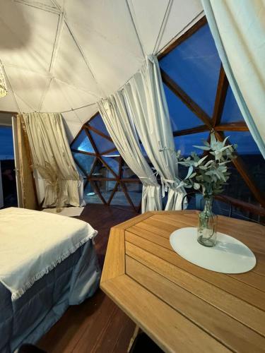 a room with a table with a vase of flowers on it at Glamping il Tramonto in Villa Amancay