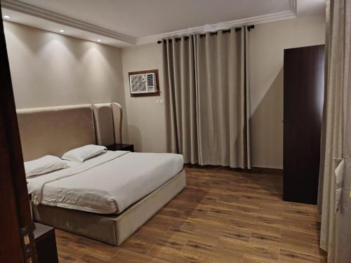 a bedroom with a bed with white sheets at خزامى للشقق المخدومة in Sufan
