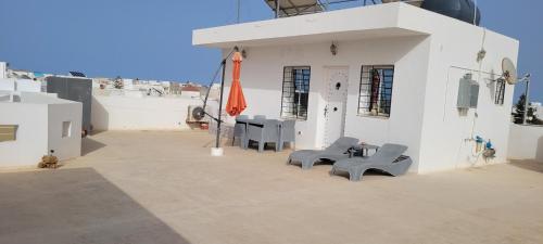 a building with two chairs and a table on the side at Rooftop Apartment in Monastir