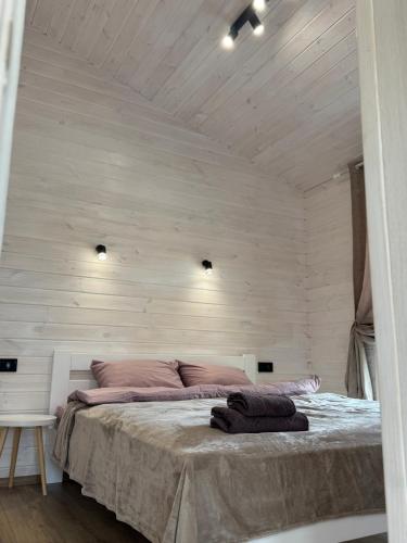 a bedroom with a large bed with white walls at Райське містечко «Акваторія» in Perlivka