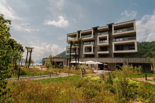 a building with a garden in front of it at Swiss Diamond Boutique Hotel - La Romantica in Melide