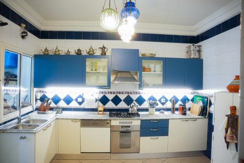 a blue and white kitchen with blue cabinets at Dar Ullaya in Hammamet
