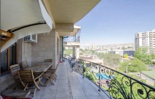 a balcony with a wooden table and chairs on a building at Luxury Villa in Yerevan in Yerevan