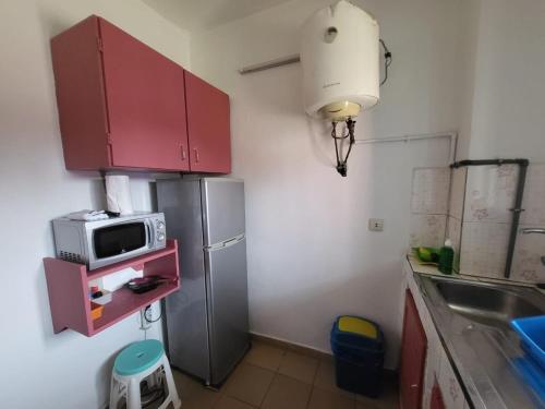 a kitchen with a refrigerator and a microwave on a shelf at chic studio - 10 minutes du plateau in Abidjan