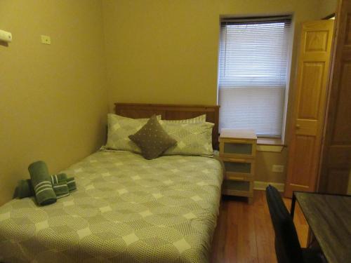 a bedroom with a bed and a table and a window at Hyde Park Shared Apartments in Chicago