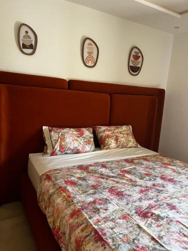 a bed with a wooden headboard and two pillows at Luxury appartment avec piscine à la Marina Saidia in Saidia 