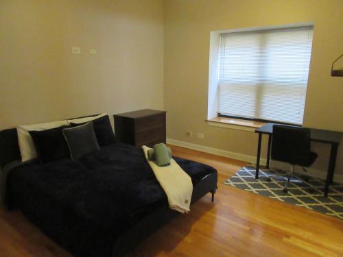 a bedroom with a bed and a desk and a window at Hyde Park Shared Apartments in Chicago