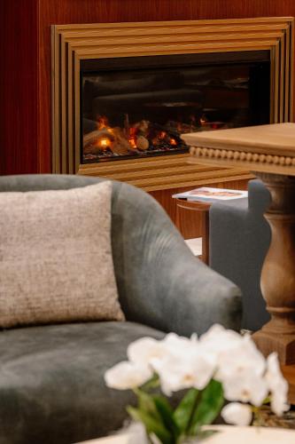 a living room with a chair and a fireplace at Swiss Diamond Boutique Hotel - La Romantica in Melide