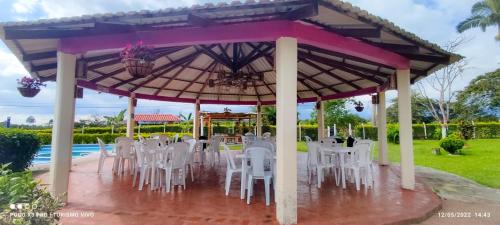 a group of tables and chairs under a pavilion at Finca Hotel el Rocio in Circasia