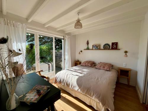 une chambre avec un lit et une grande fenêtre dans l'établissement Kerlou, à Crozon