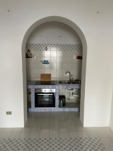 an archway in a kitchen with a sink and a stove at Eolian Villa Mare - Floating over the sea in San Salvatore