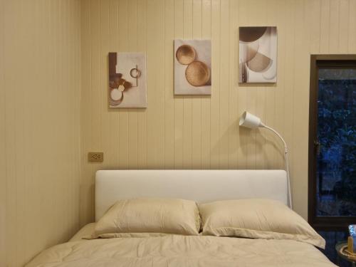 1 cama en un dormitorio con cuadros en la pared en Hidden Gem Cozy House, en Wok Tum