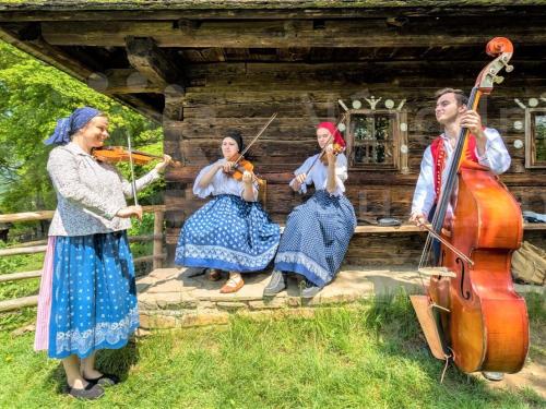 a group of women playing music in front of a cabin at Apartmány Vila Hedvika in Rožnov pod Radhoštěm