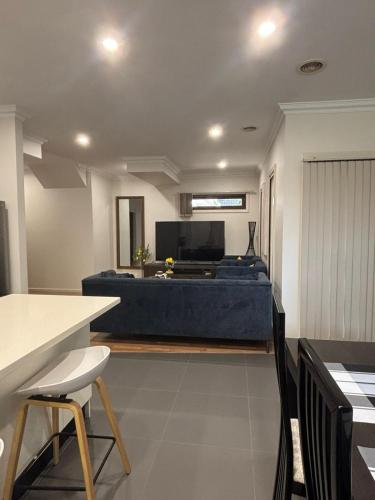 a living room with a couch and a table and chairs at Urban Pause - Epping in Epping