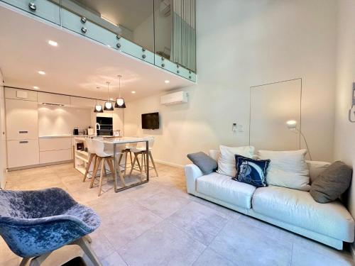 un salon avec un canapé blanc et une table dans l'établissement La Verrière du Palais - Triplex contemporain avec jardin, à Avignon