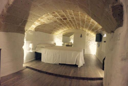 a bedroom with a white bed in an archway at La casa del nonno in Matera