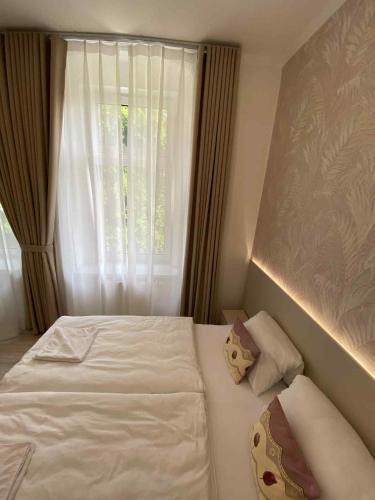 a bedroom with a white bed and a window at Hotel U Radnice Aš in Aš