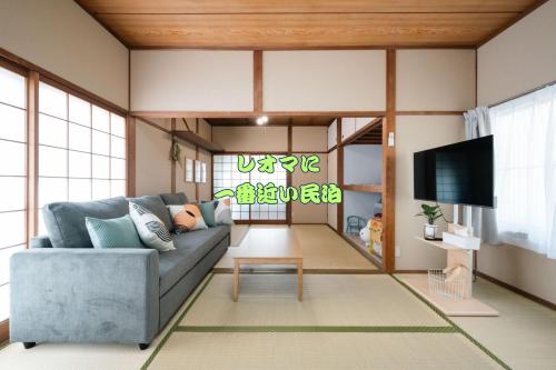 a living room with a couch and a tv at くりくまのいえNostalgic JPN House cottage 2BDR in Marugame