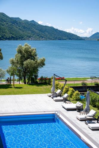 a swimming pool with chairs and a view of the water at Swiss Diamond Boutique Hotel - La Romantica in Melide