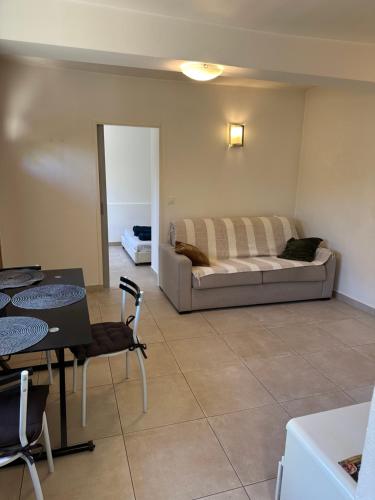 un salon avec un lit, une table et des chaises dans l'établissement Agréable 2 pièces en ville comme à la campagne, à Nice