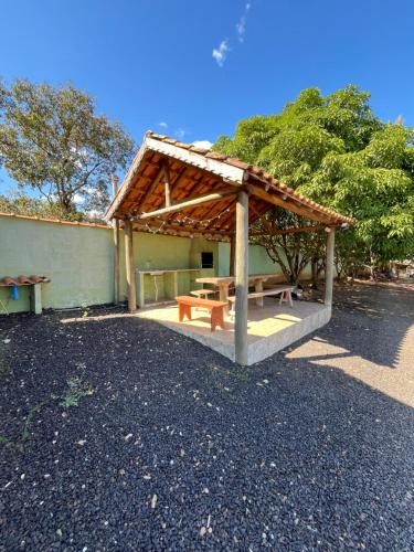 a picnic shelter with a picnic table in a parking lot at Quintal De Minas in Delfinópolis