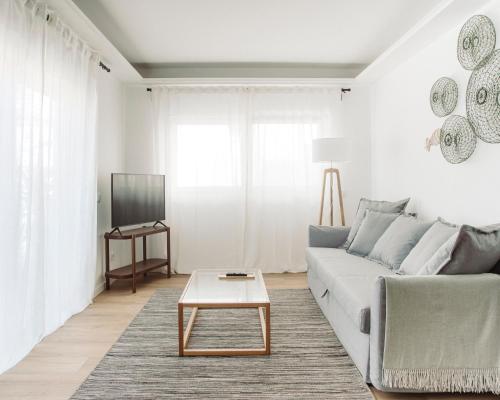 a living room with a couch and a coffee table at Salicórnia in Olhão