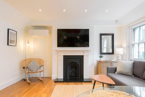 a living room with a couch and a fireplace at Bright Carnaby Soho 1BR Apartment with AC in London