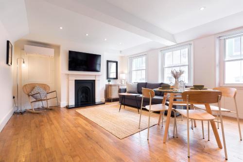 a living room with a table and a couch at Bright Carnaby Soho 1BR Apartment with AC in London