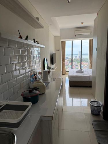 a kitchen with a sink and a bed in a room at Pollux Habibie Deluxe Sea View By Superstay in Batam Center