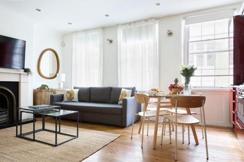 a living room with a couch and a table at Modern Carnaby Soho 1BR Apartment with AC in London